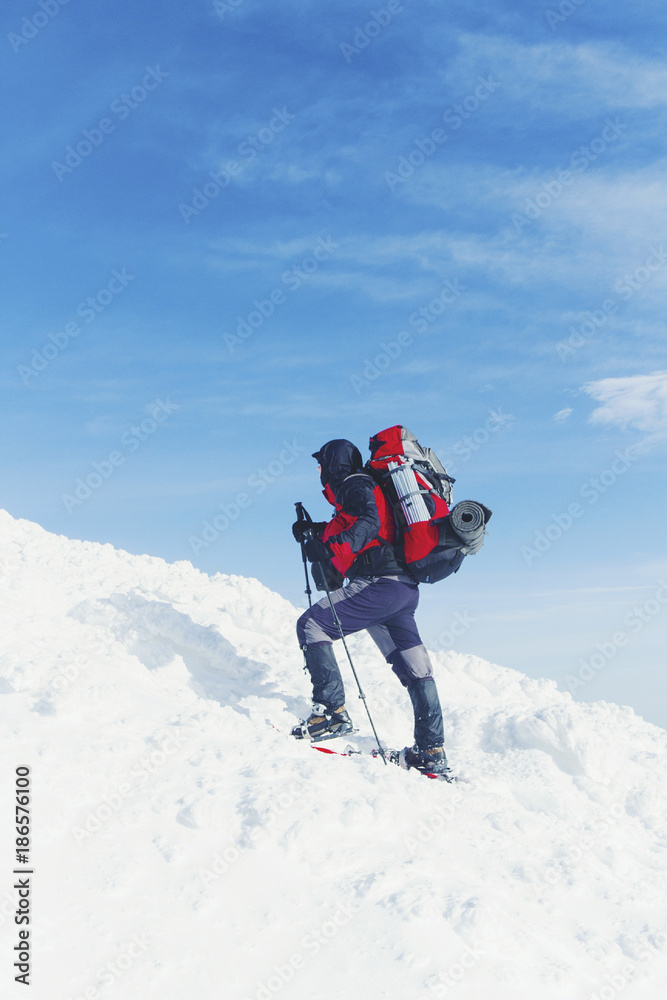 Snowshoe walker running in powder snow with beautiful sunrise light. Outdoor winter activity and healthy lifestyle