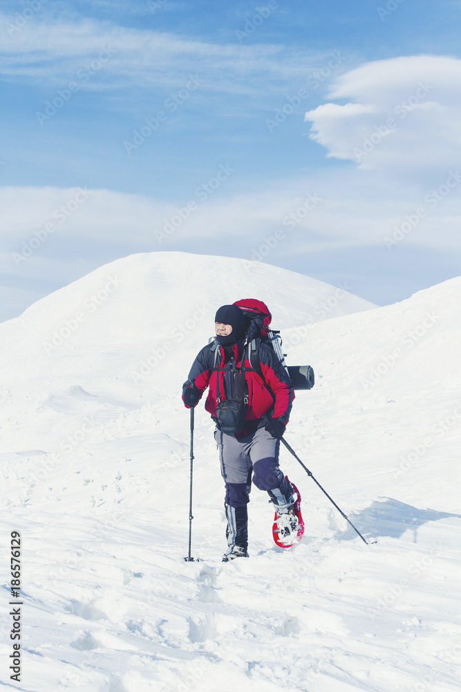 Snowshoe walker running in powder snow with beautiful sunrise light. Outdoor winter activity and healthy lifestyle Snowshoe walker running in powder snow with beautiful sunrise light. Outdoor winter activity and healthy lifestyle