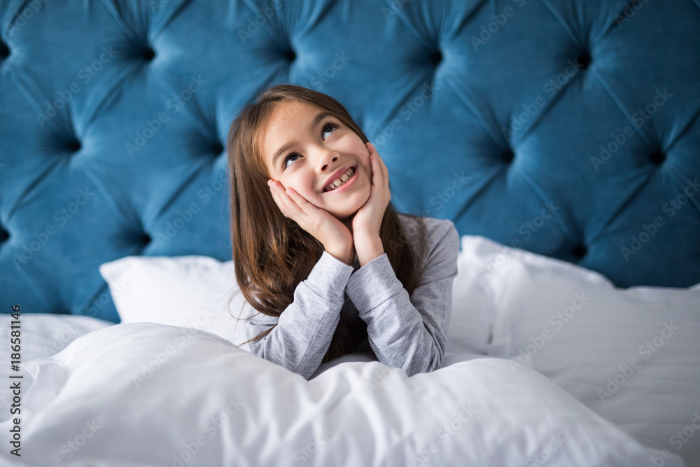 happy little girl with smile and pillow in bed at home happy little girl with smile and pillow in bed at home