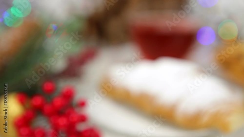 a cup of tea with honey and croissant , a branch of a Christmas tree in the snow, Christmas lights