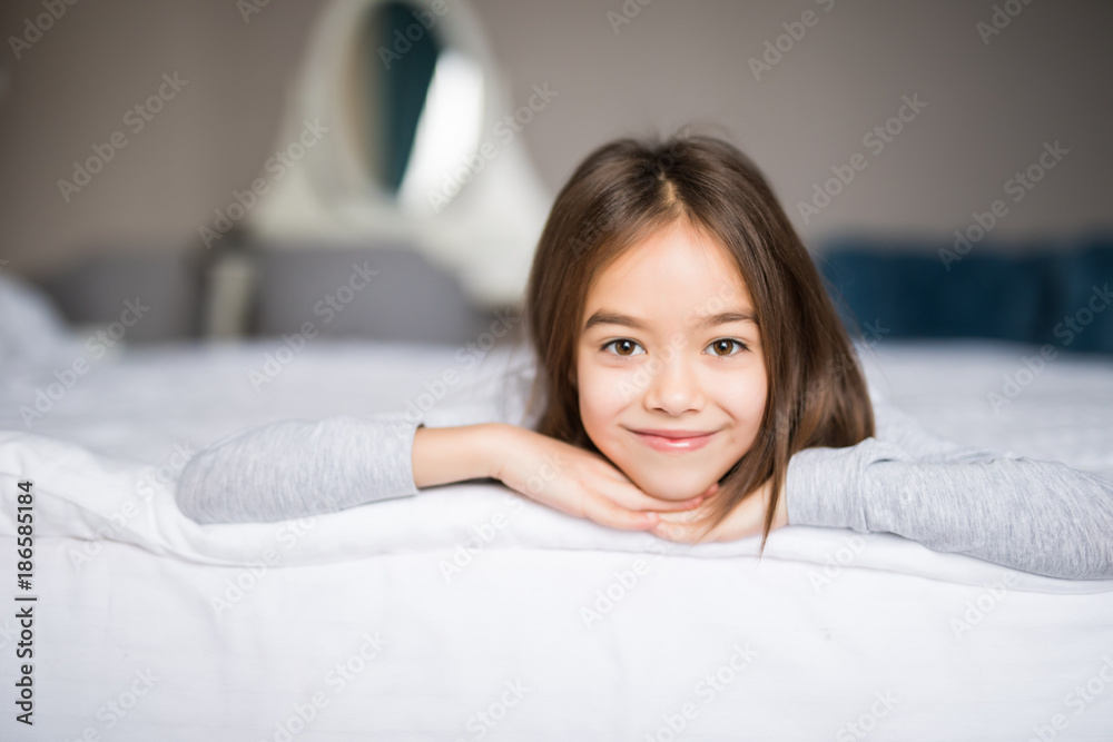 Adorable smiling little girl waked up in her bed at home Adorable smiling little girl waked up in her bed at home