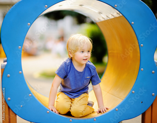 Little boy having fun on outdoor playground/on slide