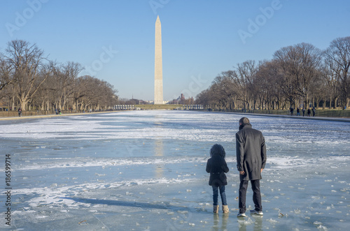 Φωτογραφία A man and child walk on the frozen reflecting pool of the Lincoln Memorial, turned to ice by many days of sub-freezing temperatures in Washington DC