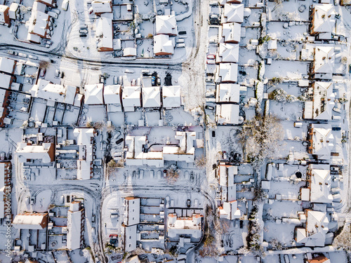 Aerial view of snow covered traditional housing suburbs in England. Snow, ice and adverse weather conditions bring things to a stand still in the housing estates of a British suburb © Kev303