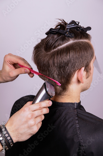 The process of male haircuts. A hairdresser is cutting a guy. Barber does a haircut.Hair will be sheared, hair cut. The machine for a hairstyle