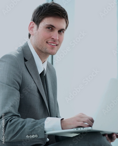 closeup of a successful young male blogger with an open laptop s photo