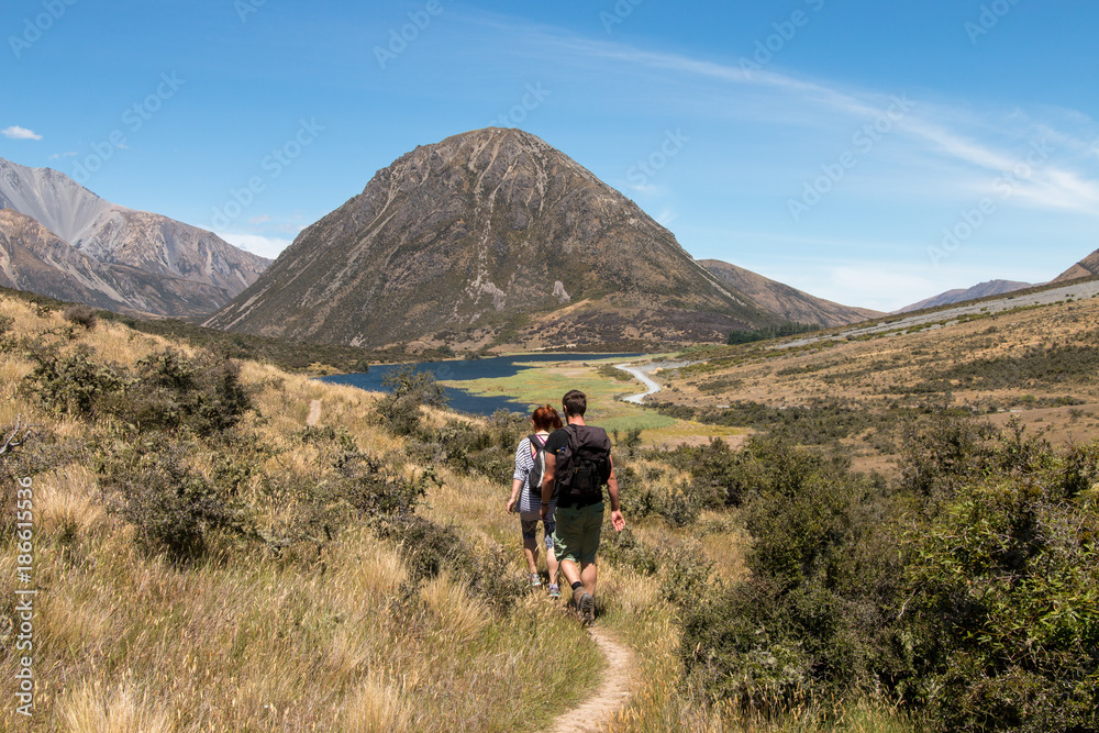 Young couple on walking trail to lake Ida, Canterbury, New Zealand