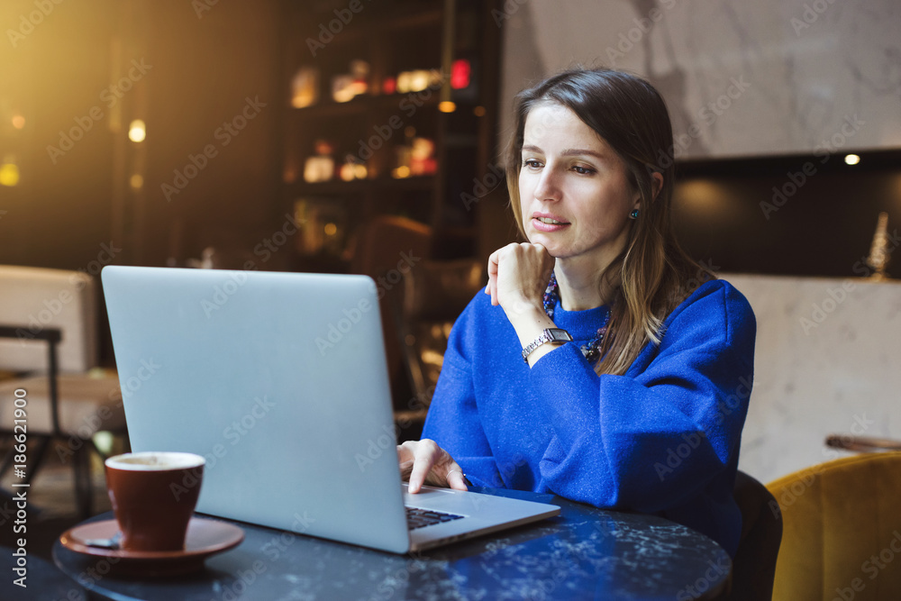 Business woman using laptop while sitting at cafe Business woman using laptop while sitting at cafe