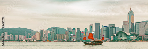 Photography Hong Kong skyline at sunset panoramic banner background with junk boat sailing in sunlight