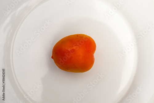 One Orange Tomato on White Plate