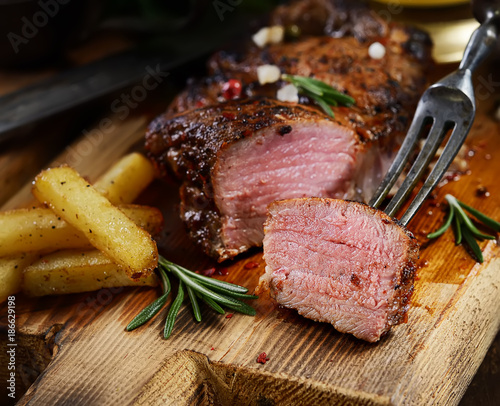 grilled juicy steak with rosemary.