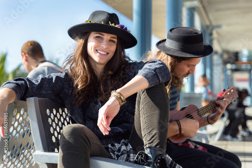 Eccentric stylish hipster man and woman hanging out at train station during travel abroad