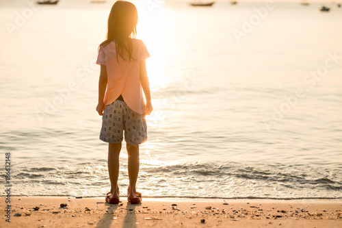 travel background girl stand alone on beach looking beautiful sea sunset. image for person, nature, portrait, landscape, scenery, evening concept