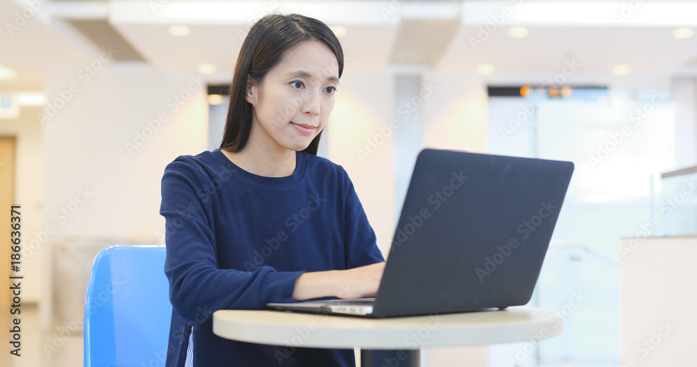 Woman doing homework on laptop computer inside university campus Woman doing homework on laptop computer inside university campus
