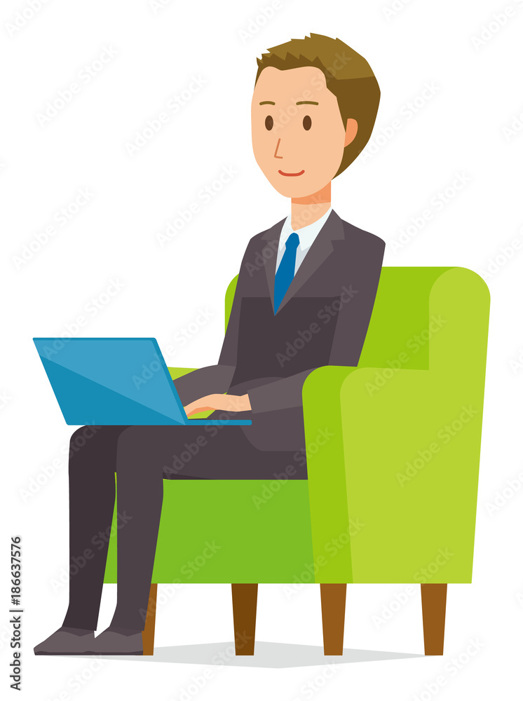 A young businessman is sitting on the sofa and operating a laptop computer