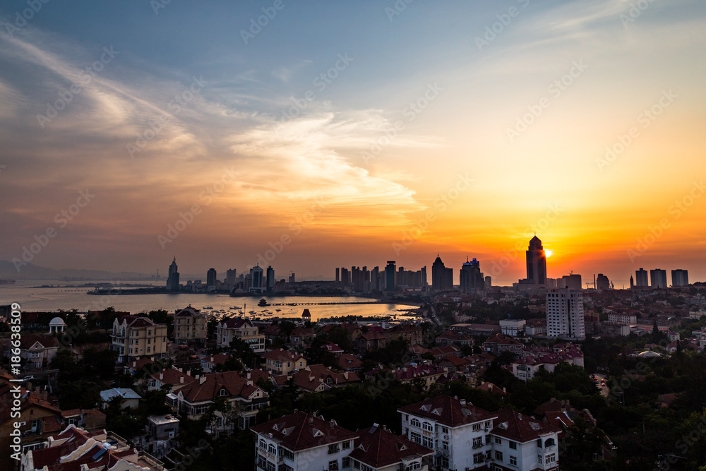 View of Old town and Qingdao bay from the hill of XiaoYuShan Park at sunset, Qingdao, China.