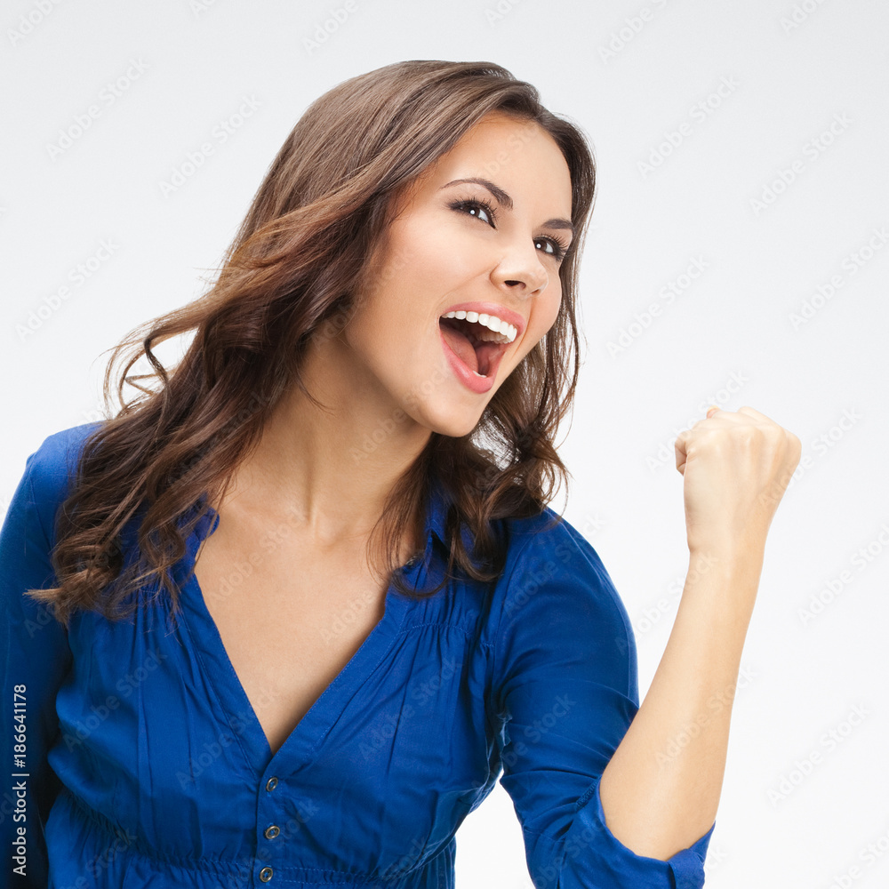 Happy gesturing cheerful gesturing businesswoman, on grey Happy gesturing cheerful gesturing businesswoman, on grey