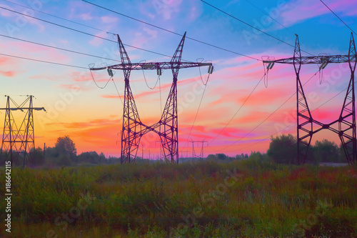 Metal rod posts of high-voltage power lines, the view at sunset