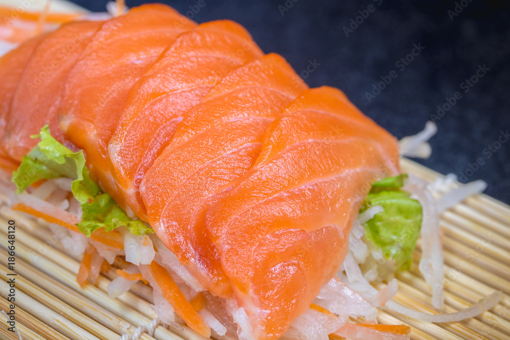 Close up raw fresh salmon sashimi set salad on black table. Close up raw fresh salmon sashimi set salad on black table.