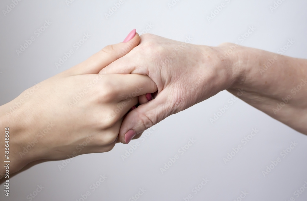hands of an elderly woman holding young girl hands of an elderly woman holding young girl