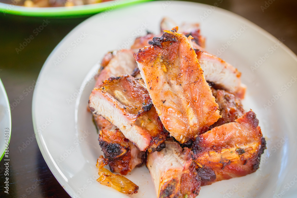 Roasted ribs cut into pieces on a plate. Roasted ribs cut into pieces on a plate.