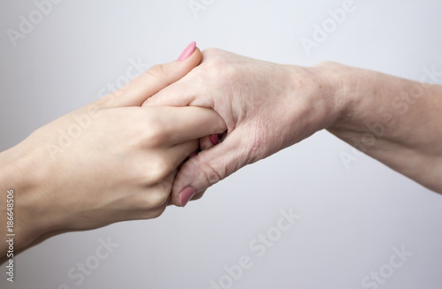 hands of an elderly woman holding young girl