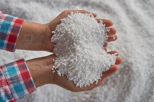 Nitrogen fertilizers or urea fertilizer in farmer hand. blur.white fertilizer background.