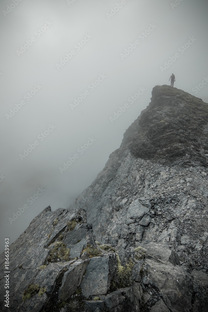 Man standing on the peak of a mountain