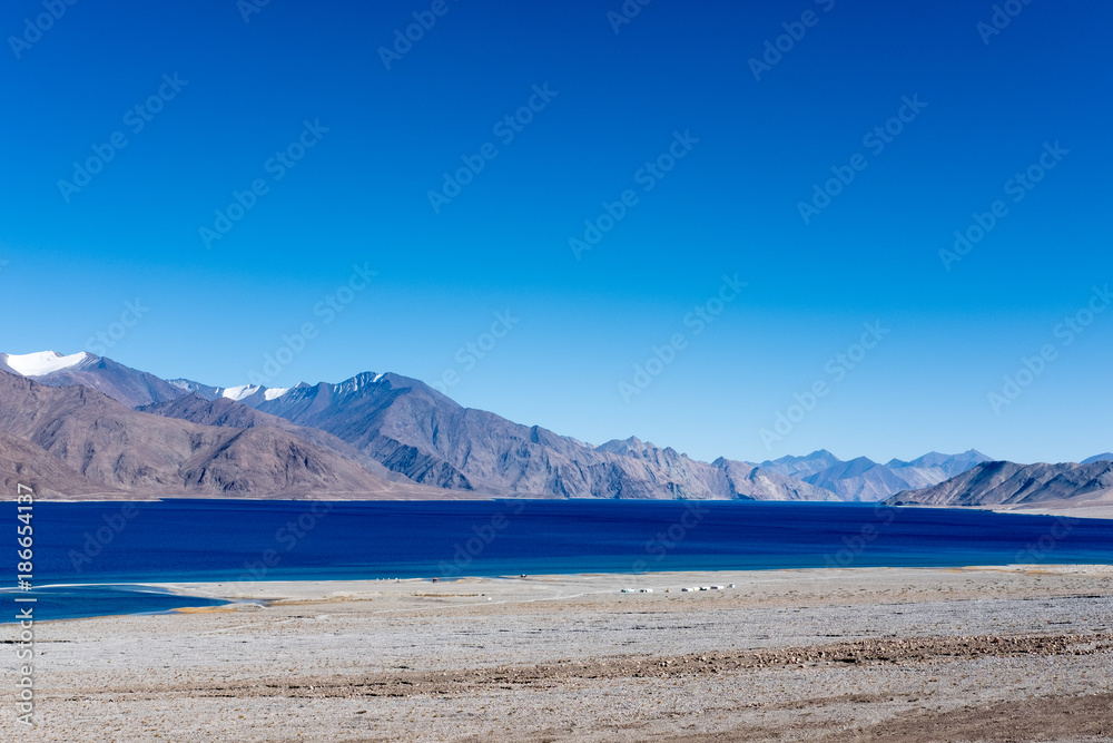 Landscape image of Pangong lake with mountains view and blue sky background