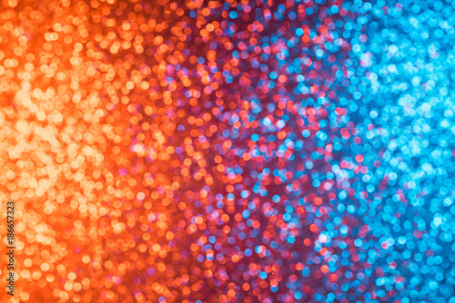 Multicolored orange red and blue shiny abstract blurred festive bokeh lights background