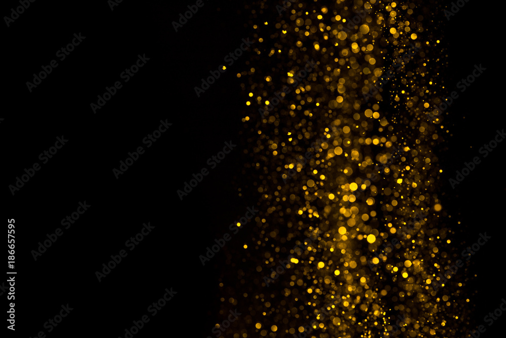 Falling glitter dust bright bokeh border on black background with copy space