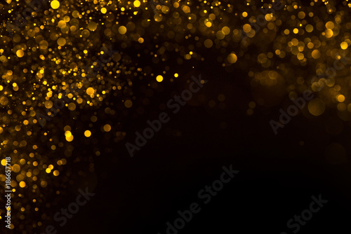 Shiny gold glitter flowing dust border frame on dark background