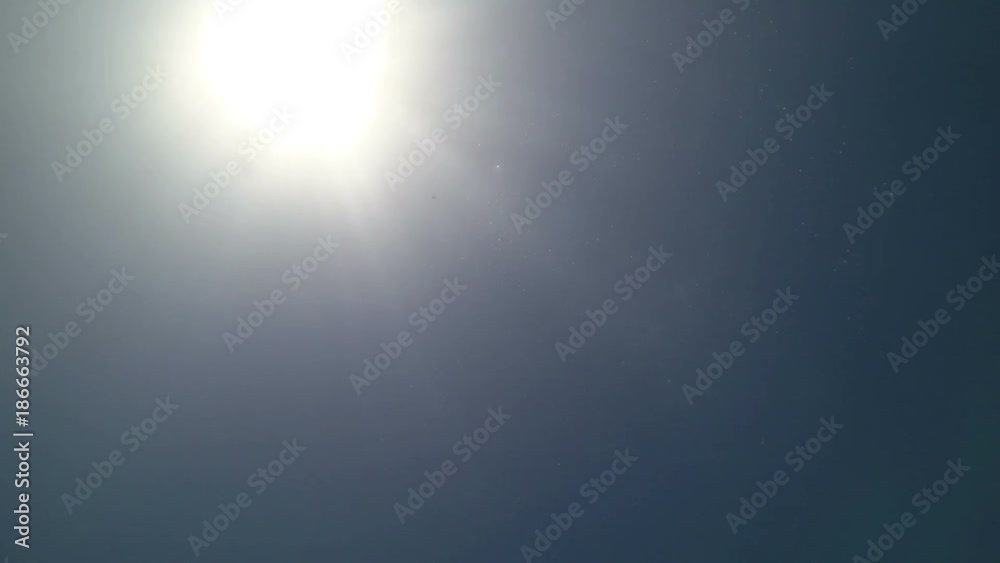 Underwater view of man on inflatable mattress swimming in sea water