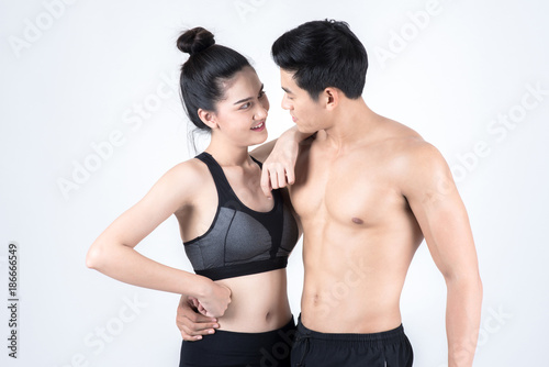 Fitness and health concept. Portrait of fit sport man and woman looking confidence, isolated on white background. Half naked Asian chinese lean muscular male wearing a black shorts with chinese woman.