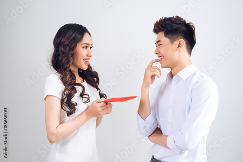 Vietnamese couple exchanging red lucky money envelopes. Tet holiday.