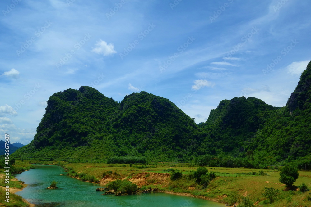 Green water stream with mountains in the background in Phong Nha, Ke Bang National Park, Vietnam