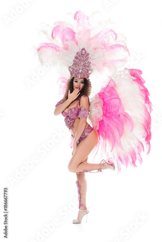 girl with oops gesture in carnival costume with pink feathers, isolated on white