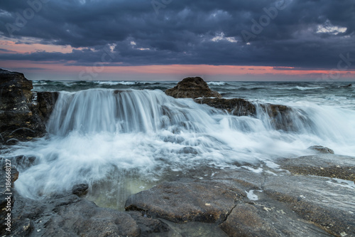 Water flows into the rocky beach
