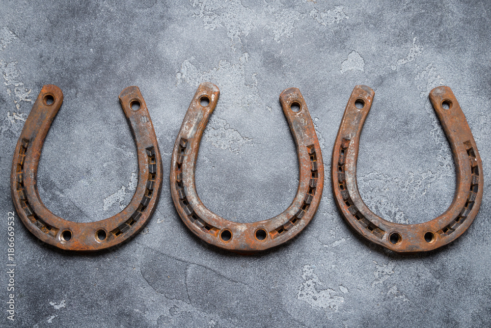 Rustic iron horseshoe on grey background Rustic iron horseshoe on grey background