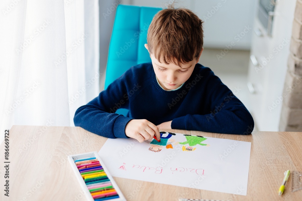 8 letni chłopiec maluje kredkami obrazek lurkę dla swojej babci na Dzień Babci - obrazy, fototapety, plakaty 
