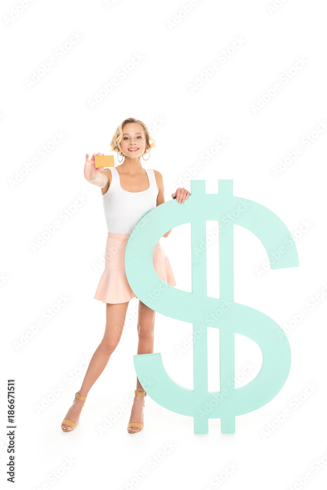 smiling woman showing credit card in hand while standing near dollar sign isolated on white smiling woman showing credit card in hand while standing near dollar sign isolated on white