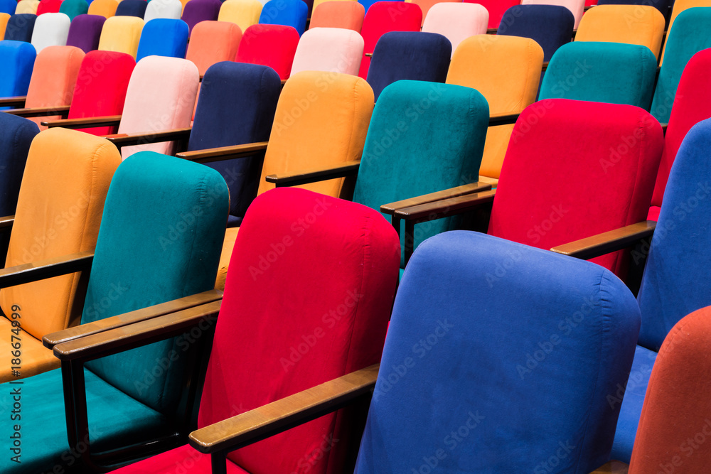 Fototapeta premium The auditorium in the theater. Multicolored spectator chairs.