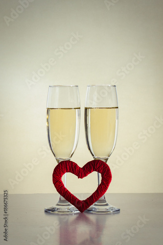 Two glasses with champagne and red heart handmade