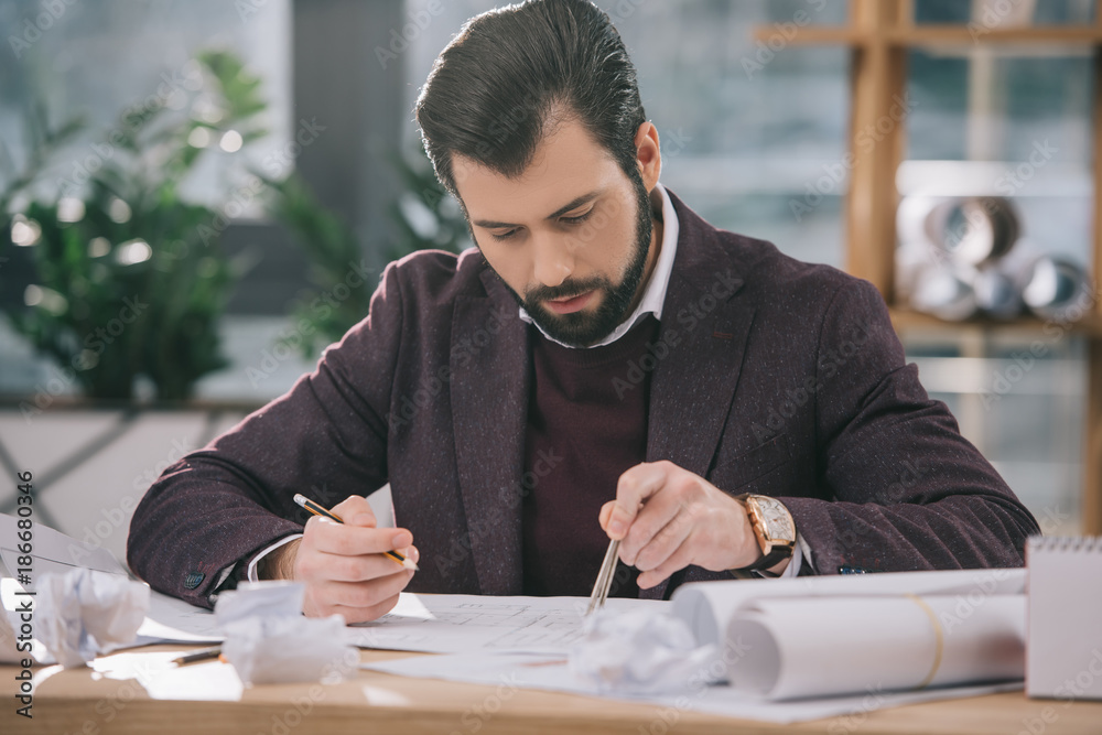 architect drawing building plans with compasses at workplace with crumpled papers architect drawing building plans with compasses at workplace with crumpled papers