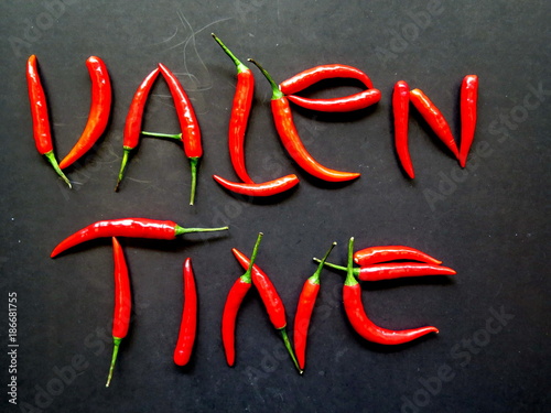 Red pepper chili design in letter word Valentine on black background, spicy tasty, Valentine's day festival concept 