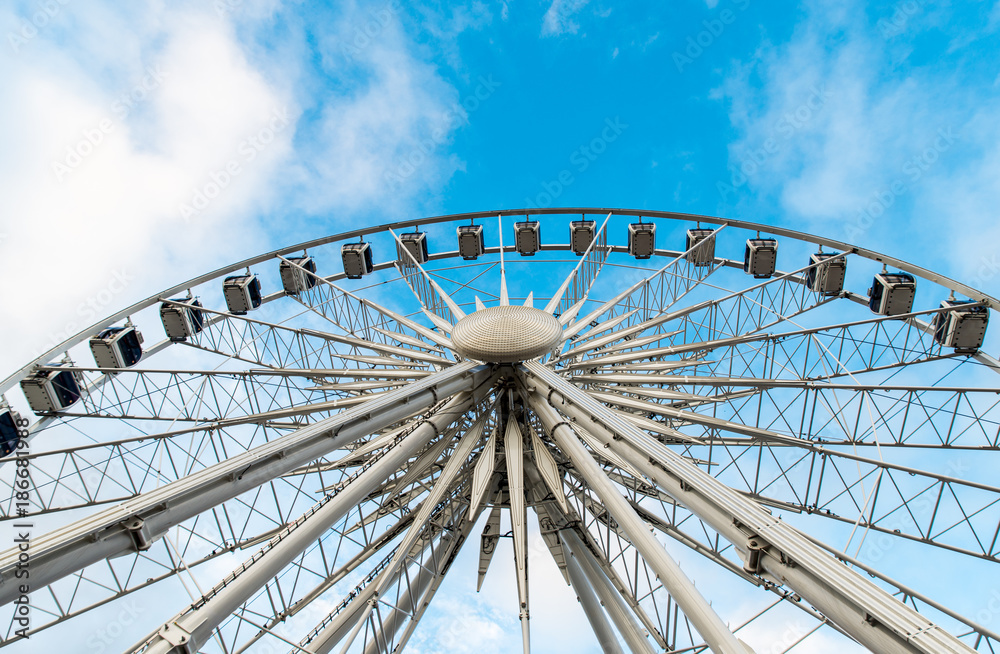 Gdansk, Poland - August 10, 2017: Big ferris wheel in the old town of Gdansk, blu sky background. Center or old town in Gdansk, European polish culture city near baltic sea. Summer travel in Poland. Gdansk, Poland - August 10, 2017: Big ferris wheel in the old town of Gdansk, blu sky background. Center or old town in Gdansk, European polish culture city near baltic sea. Summer travel in Poland.