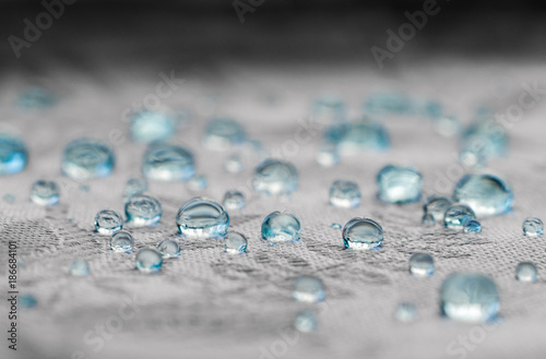 Blue drops on water resistance surface of textile fabric fibers. Macro 