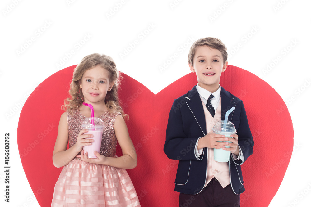 cute little kids holding milkshakes in plastic cups and big red heart symbol behind isolated on white cute little kids holding milkshakes in plastic cups and big red heart symbol behind isolated on white