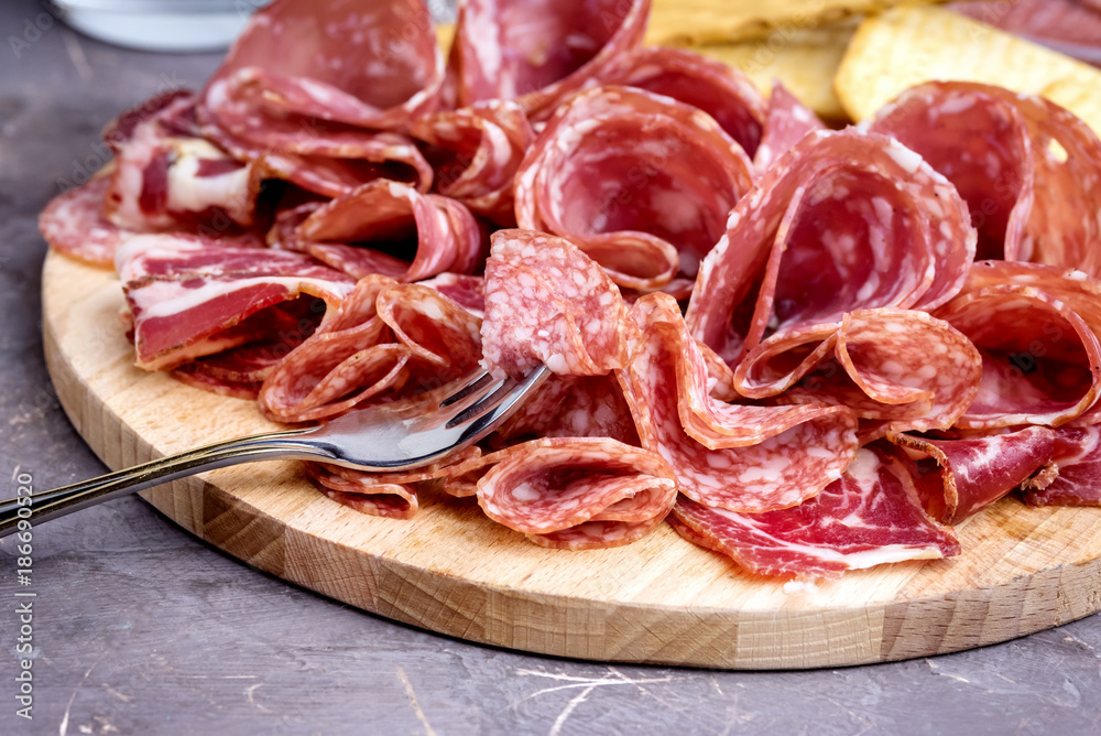 Food Tray With Delicious Salami Pieces of Sliced Ham and Crackers and Bread Sticks Meat Plate Close Up Food Tray With Delicious Salami Pieces of Sliced Ham and Crackers and Bread Sticks Meat Plate Close Up