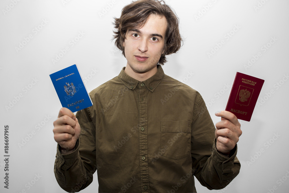 Man showing two different passports on the white background. Tourism and travel concept. Selective focus and shallow DOF. Man showing two different passports on the white background. Tourism and travel concept. Selective focus and shallow DOF.